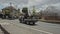 A car moving along the road with special people watering the street from spray with chemical reagents to protect against the virus