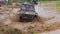 The car overcomes difficult obstacles. Large-scale sports competitions of off-road cars