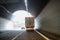 Car overtakes truck at the exit of the highway tunnel.