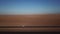 Car parked on asphalt road in aerial desert. Sandy landscape, nobody in Namibia.