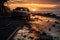 a car is parked on the beach at sunset