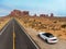 Car parked on the desert asphalt road in Monument Valley in Arizona. USA West coast travel destination concept