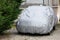 Car parked with protective cover silver in home garden