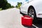 A car parked on the side of the road, an empty red canister. The driver is on the road. Help on the road. Fuel shortage