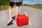 A car parked on the side of the road, an empty red canister. The girl stops on the road to fill up the car. Fuel shortage - oil,