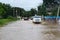 Car passes through a flooded street, damage after a storm. Floods and natural disasters.