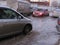 The car passes on the street flooded with meltwater with the stuck cars flooded with a flood