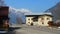 Car passing hotel and filling station, snowy mountains and blue sky background