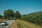 Car passing through paved road on rural landscape