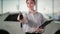 car purchase, young woman holding automobile keys in her hands in auto center, close-up