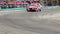 Car race competitors drifting in hot pursuit, turning sharp turn