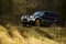 Car racing in autumn forest. Extreme, challenge, and 4x4 vehicle concept. Offroad race on fall nature background. SUV or