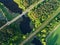 Car and railway roads across the lake in green forest