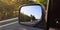 Car rear view mirror with the image of a biker approaching to overtake