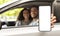 Car Rental App. Arab Couple Showing Blank Smartphone While Sitting In Auto