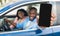 Car Rental App. Black Family Sitting In Auto Showing Blank Smartphone