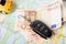 Car rental concept - car key and money on the map