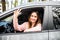 Car rental happy woman in her car near the beach showing victory sign