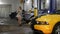 Car repair service. A young woman in small shorts walking around the cars and chooses the sport car