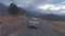 Car riding on serpentine asphalt road desert mountain valley enjoy travel journey aerial view