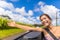 Car road trip woman freedom with hand floating in the wind. Asian girl sitting in convertible automobile carefree