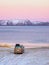 The car with roof rack is parked on the shore of the Arctic ocean. Travel concept of traveling by car. Amazing view of the