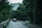 Car in rural road in deep rain forest with green tree forest view from above, rental car in spain mountain landscape road