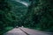 Car in rural road in deep rain forest with green tree forest view from above, rental car in spain mountain landscape road