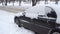 A car`s front part buried in snow after a blizzard.