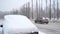 A car`s front part buried in snow after a blizzard.