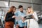 Car saleswoman shows catalog to buyers. Young couple chooses a new car