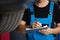 Car service employe inspect car. Mechanic inspects the car undercarriage way and makes a note on his inspection sheet