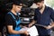 Car Service Employees Inspect the Bottom and Skid Plates of the Car. Manager Checks Data on a Tablet Computer and