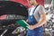 Car service, repair, maintenance and people concept - auto mechanic man or smith with clipboard at workshop