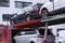 Car shipping auto transport vehicle with cars loaded in front of office buildings