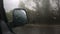 Car side mirror and drivers window with drops of rain