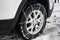 Car with snow chain on tire, closeup.