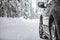 Car on a snowy winter road amid forests