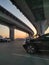 the car stands under the round bridge at sunset