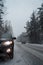 The car stopped at the curb during snowfall