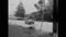 Car stopping by broken down police car on road, 1950s