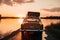 car, with suitcases on the roof, driving past lake during sunset