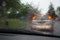 Car tail lights through a rain covered windshield, focus on rain drops