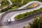 A car taking a sharp turn on a winding serpentine road near Savoca, Sicily, Italy