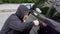 Car thief steal car breaking door criminal job burglar Hijacks Auto thief black balaclava hoodie trying break into
