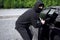 Car thief steal car breaking door criminal job burglar Hijacks  Auto thief black balaclava hoodie trying  break into vehicle