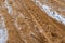 Car Tire Marks on an Empty Field Covered With Snow, closeup view - Cloudy Day