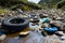 Car tire and plastic bottles in muddy puddle on beach