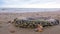 Car tire thrown by waves on the sandy shore during a storm. Tyre covered with sea shells.