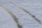 Car tire tracks on frozen ice on the lake. Off-road protector